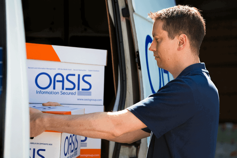 OASIS Group Team Member loading archive boxes into van